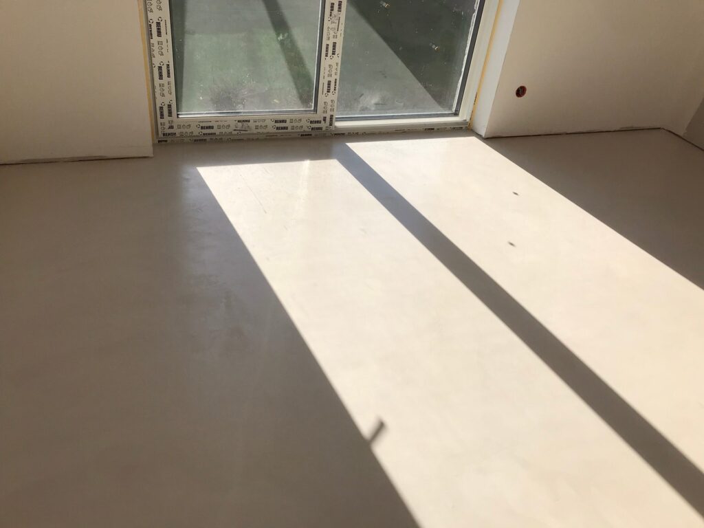 Mikrocement w salonie domu w Rumi – jedna powierzchnia od ściany do ściany (realizacja REMIBUD)